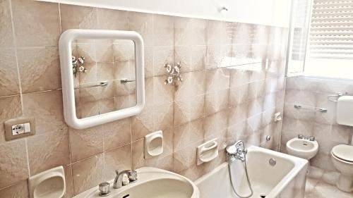 uma casa de banho com um lavatório, um WC e um espelho. em Casa Angela em Alì