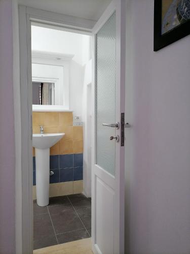 a bathroom with a sink and a glass door at Casa Vacanze "Villa Angelina" in Lipari