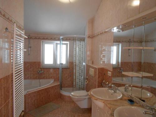 y baño con 2 lavabos, aseo y bañera. en Villa Apolonija, en Zadar