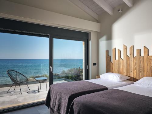 a bedroom with two beds and a view of the ocean at LaMer SeaFront Villa, Zante Zen By ThinkVilla in Kipseli