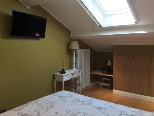 a bedroom with a bed and a television on the wall at B&B Via Roma 41 in Ventimiglia