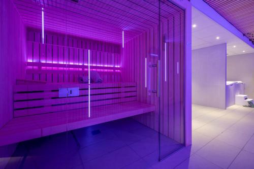 Cette chambre violette comprend un banc dans la salle de bains. dans l'établissement ATHOME RESIDENCE ET SPA, à La Rochelle