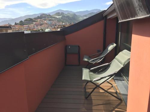 a balcony with two chairs and a view of a city at B&B Via Roma 41 in Ventimiglia