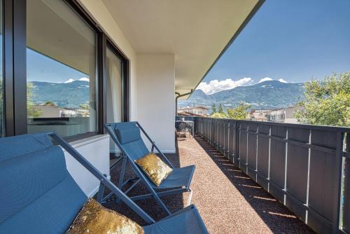 un paio di sedie blu su un balcone con vista sulle montagne di goldfinger + suites a Lana