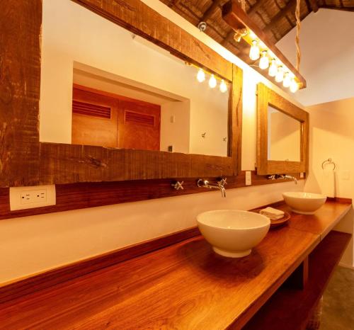 a bathroom with two sinks on a wooden counter at Mimosa Tulum in Tulum