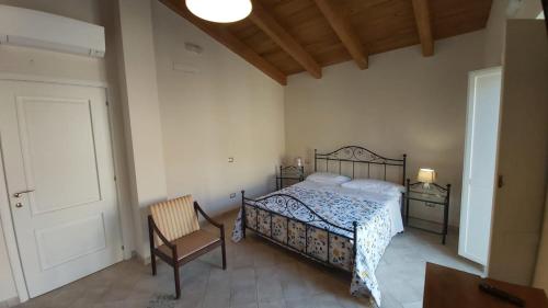a bedroom with a bed and a chair and a door at Dimora Igea b&b in Montano Antilia
