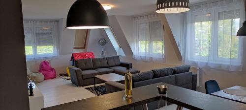 a living room with a couch and a table at IKON apartman in Hajdúszoboszló