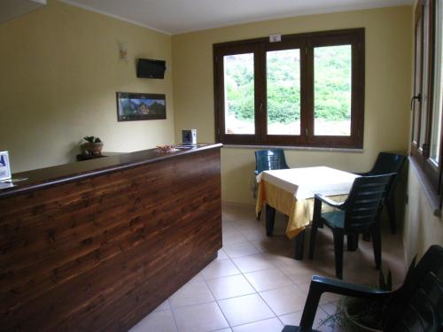 a restaurant with a counter and a table with chairs at B&B Il Vecchio Portale in Laino Borgo