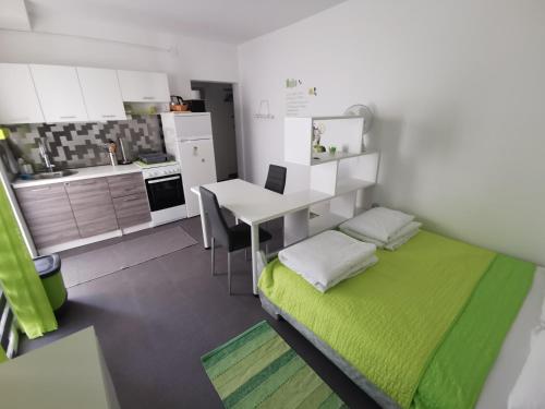 a small room with a bed and a desk and a kitchen at Laura's dream Appartments in Pag