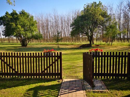 a wooden fence with flowers on it in a field at TücsökTanya Vendégház in Csemő