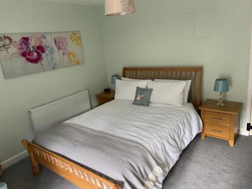 a bedroom with a bed with a picture on it at Poppy Cottage in Matlock