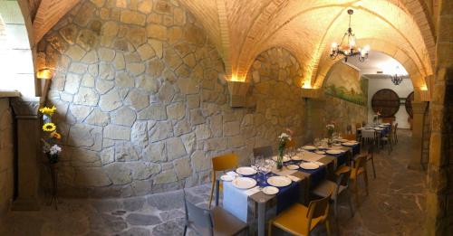 a dining room with tables and chairs and a stone wall at Pensión Ametzagaña in San Sebastián