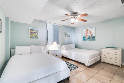 a bedroom with two beds and a ceiling fan at Dolphin Point in Destin