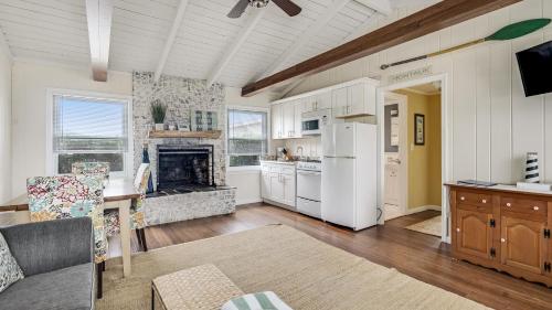 a kitchen and living room with white appliances and a fireplace at Beach Plum Resort in Montauk