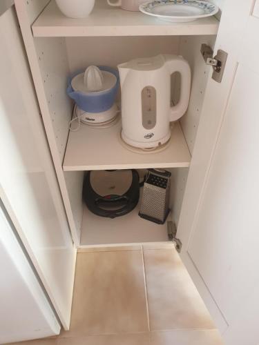 a cupboard with a mixer and other kitchen items in it at oasis RELAX Corralejo in Parque Holandes