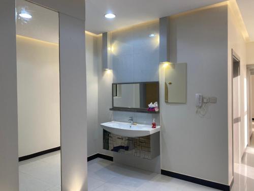 uma casa de banho com um lavatório branco e um espelho. em شالية لورينزو em Buraydah