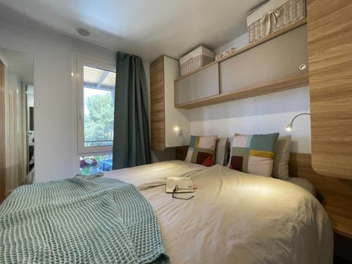 una camera da letto con un letto con un libro sopra di HARMONIA mobile home a Rovigno (Rovinj)