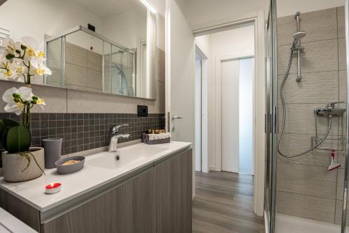 un bagno con lavandino e doccia di Laura's Little Diamond Apartment - Residence Bel Post a Domaso