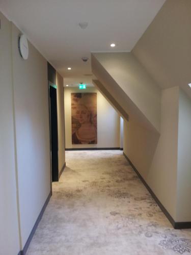 an empty hallway with a painting on the wall at Sorat Hotel Saxx Nürnberg in Nürnberg