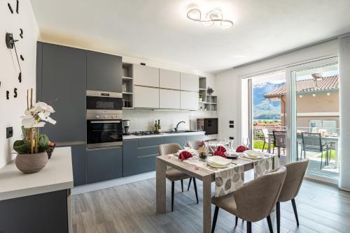 una cucina e una sala da pranzo con tavolo e sedie di Laura's Little Diamond Apartment - Residence Bel Post a Domaso