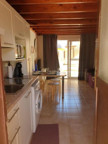 a kitchen with a sink and a table with a washing machine at oasis RELAX Corralejo in Parque Holandes