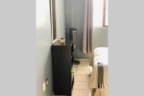 a small bedroom with a black dresser and a bed at Hermoso penthouse en el centro histórico in Zacatecas