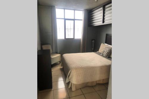 a bedroom with a bed and a window at Hermoso penthouse en el centro histórico in Zacatecas
