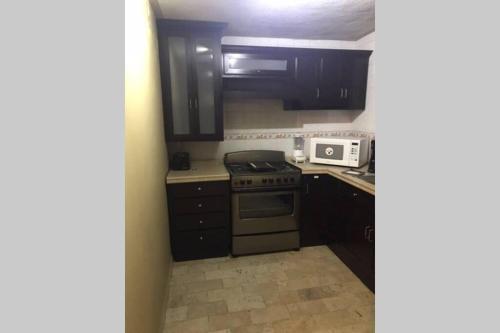 a small kitchen with a stove and a microwave at Hermoso penthouse en el centro histórico in Zacatecas