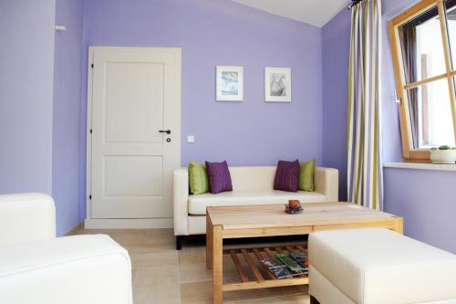 a living room with purple walls and a white couch at Perbersdorfer Heuriger in Neuhofen an der Ybbs