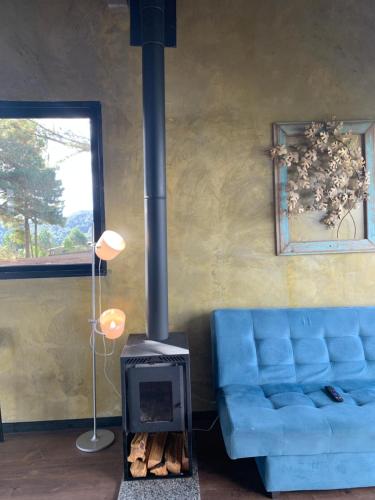 a living room with a fireplace and a blue couch at Refúgio do Canyon in Balsa Nova