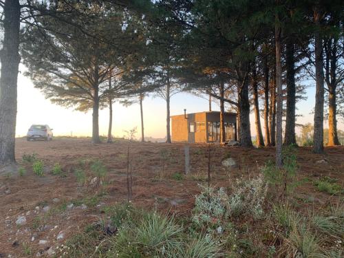 a house in the middle of a field with trees at Refúgio do Canyon in Balsa Nova