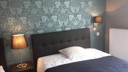 a bedroom with a bed with a blue and white wallpaper at Hotel La Fayette in Rochefort