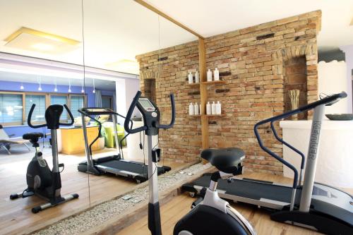 a gym with tread machines and a brick wall at Perbersdorfer Heuriger in Neuhofen an der Ybbs