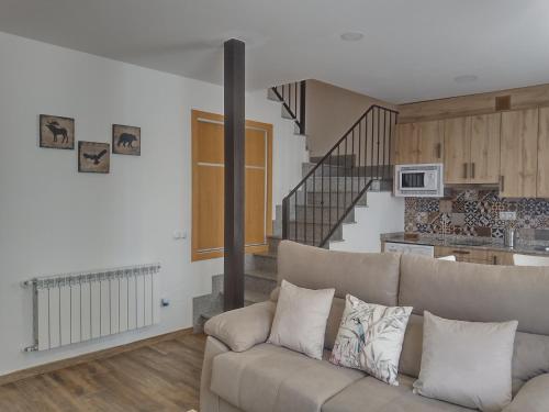 a living room with a couch and a staircase at APARTAMENTOS TURISTICOS LAS CANDELAS in Puebla de Sanabria