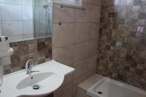 La salle de bains est pourvue d'un lavabo et d'une douche. dans l'établissement VILLA IATROU, à Potos