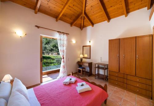 a bedroom with a large bed and a window at DELPHINUS VILLAS-Villa Nikitas in Agios Nikitas