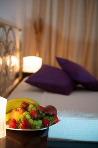 a plate of fruit on top of a bed at Chateau de Georges in Gythio