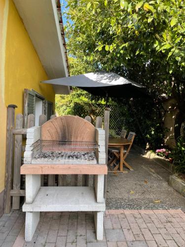 a bench with an umbrella next to a table at Home Sweet Home in Gallicano nel Lazio