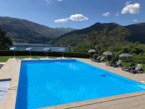 a swimming pool with a view of a lake and mountains at Hotel Portas do Gerês in Geres