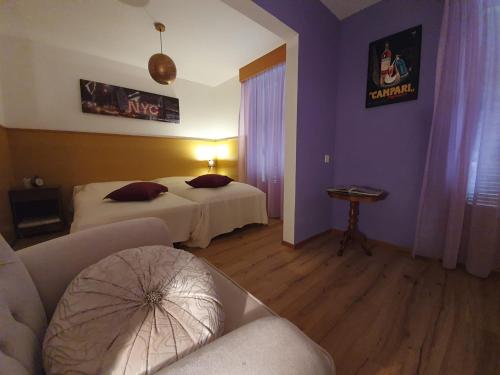 a hotel room with two beds and a couch at Cuore Alpino in Olivone