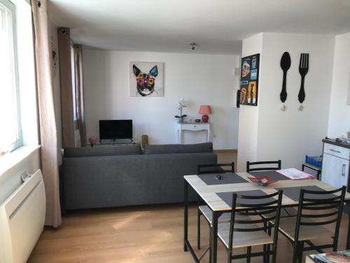 a living room with a couch and a table with chairs at Coeur Alsace in Colmar