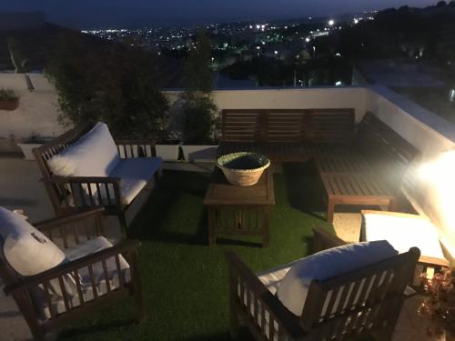 a patio with chairs and a table on a roof at night at Residenza Parco Gioeni in Catania