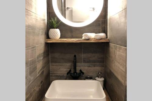 W łazience znajduje się umywalka i lustro. w obiekcie Un petit Vintage à Colmar w mieście Colmar