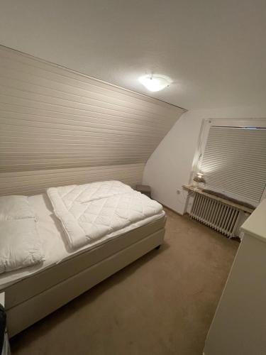 a bedroom with a bed and a window at FeWo zum Surgrund in Cuxhaven