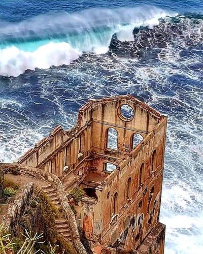a clock tower in the ocean next to the ocean at Canarian House with views and pool in Los Realejos