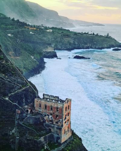 an old building on the side of a cliff near the ocean at Canarian House with views and pool in Los Realejos