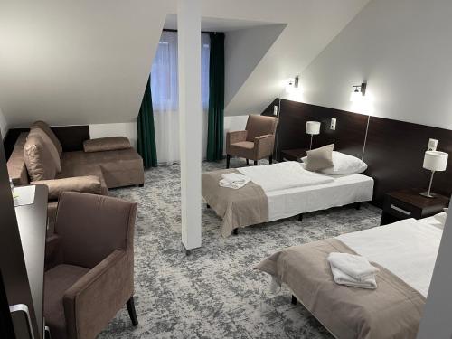 a hotel room with two beds and a couch at Hotel Mużakowski in Łęknica