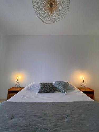 a bedroom with a bed with two lamps and a fan at Résidence Casarella Lama in Lama