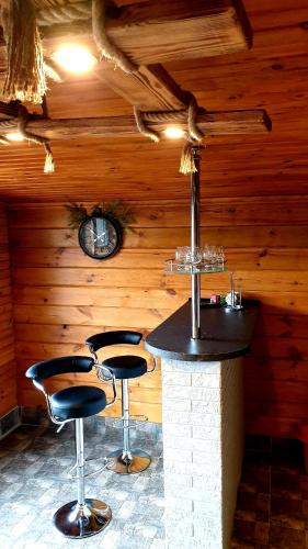 a bar in a wooden room with two stools at Садиба For Rest in Svityazʼ