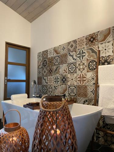 La salle de bains est pourvue d'une baignoire, d'un lavabo et de carrelage. dans l'établissement Suite parentale Au bonheur des ours, à Sahorre